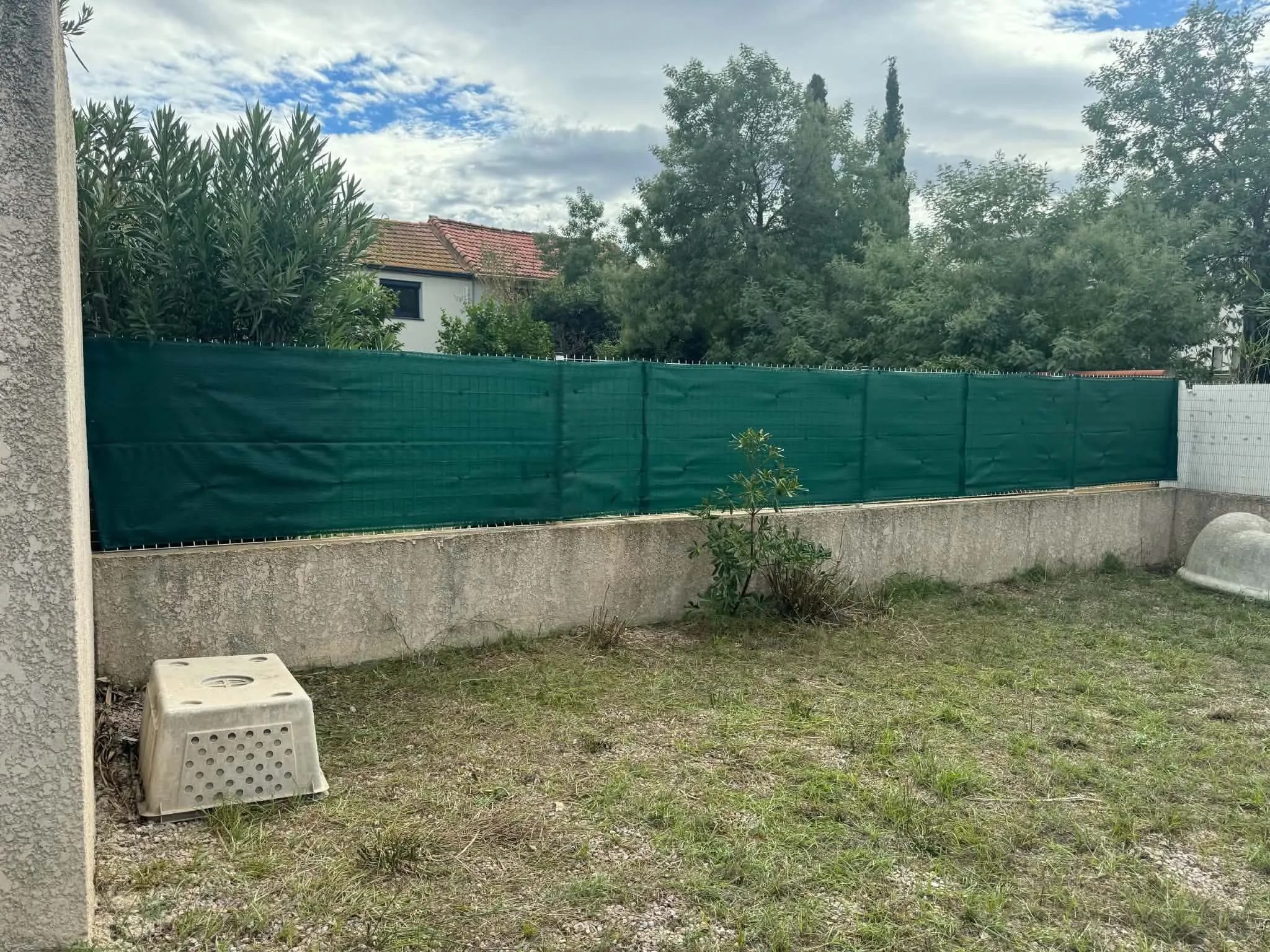 Brise-vue vert tendu sur toute la longueur de la clôture, jardin à l’abri des regards