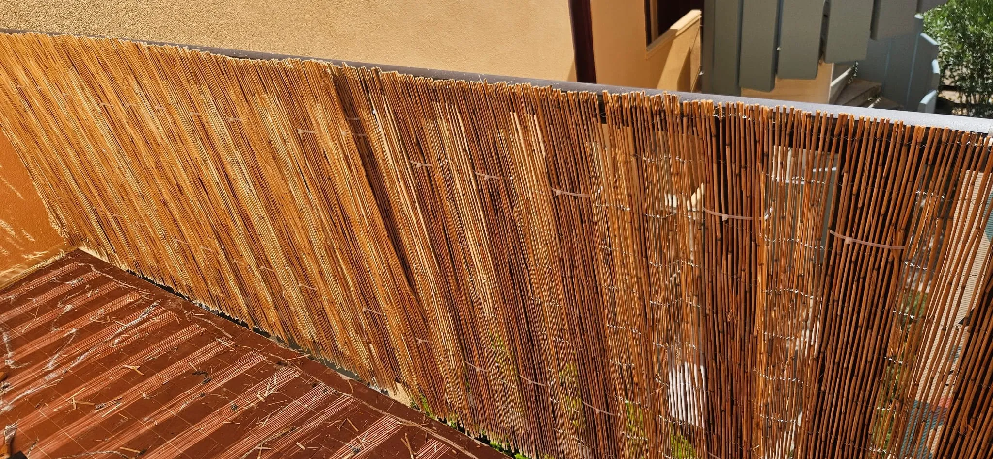 Canisse en roseau fixée le long du garde-corps du balcon